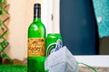 Alcohol liquor wine beer placed on grass at the entrance of house with mask and sanitizer showing home delivery of