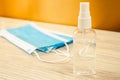 Alcohol sanitizer hand spray in a transparent plastic vial and several medical surgical masks to protect against