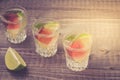 Alcohol shots with a lime/Alcohol shots with a lime on wooden bar counter. Top view