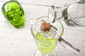 Alcohol and spirits, the green fairy and dangerous liquor conceptual idea with crystal glass of absinthe, bottle pouring water on