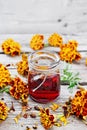 Alcohol tincture of marigolds in jar on old wooden board Royalty Free Stock Photo