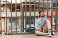 Alcoholic asian man drink beer from the bottle sitting on the floor after party. Sad heartbroken young man holding beer bottle in Royalty Free Stock Photo