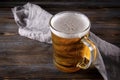 Alcoholic beverage , glass of light barley beer with foam on a gray napkin on a dark wooden background Royalty Free Stock Photo