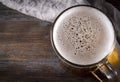 Alcoholic beverage , 1 glass of light  beer with foam on a gray napkin on a dark wooden background,  top view, close up Royalty Free Stock Photo