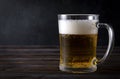 Alcoholic beverage , mug of light beer with foam on a dark wooden background Royalty Free Stock Photo