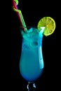 Alcoholic blue cocktails on a black background, in a tall glass