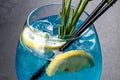 Alcoholic cocktail blue curacao with ice, lemon and cocktail tubes Royalty Free Stock Photo