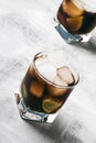 Alcoholic cocktail cuba libre with ice, lime, juice, cola and golden rum, gray bar counter background, selective focus Royalty Free Stock Photo