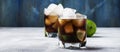 Alcoholic cocktail cuba libre with ice, lime, juice, cola and golden rum, gray bar counter background, selective focus Royalty Free Stock Photo