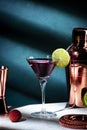 Alcoholic cocktail drink with vodka, dry gin, lychee, lime and ice in martini glass, dark green background, bright hard light and Royalty Free Stock Photo