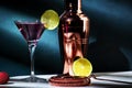 Alcoholic cocktail drink with vodka, dry gin, lychee, lime and ice in martini glass, dark green background, bright hard light and Royalty Free Stock Photo