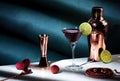 Alcoholic cocktail drink with vodka, dry gin, lychee, lime and ice in martini glass, dark green background, bright hard light and Royalty Free Stock Photo