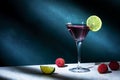 Alcoholic cocktail drink with vodka, dry gin, lychee, lime and ice in martini glass, dark green background, bright hard light and Royalty Free Stock Photo