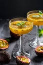 Alcoholic cocktail with fresh passion fruit and mint on black background Royalty Free Stock Photo