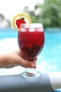 Berry-fruit cocktail with lemon and strawberries on the side of the pool