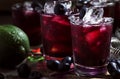 Alcoholic cocktail with liqueur, blueberry, lime juice, crushed ice, bar tools on black background, selective focus Royalty Free Stock Photo