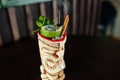 Alcoholic cocktail with mint and lime with fire in originally voodoo earthen glass on bar table. Royalty Free Stock Photo