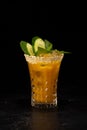 Alcoholic cocktail with orange juice, ice and cucumber and sesame decoration Royalty Free Stock Photo