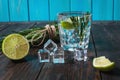 Alcoholic drink - gin tonic cocktail - with lime, rosemary and ice on rustic wooden table Royalty Free Stock Photo