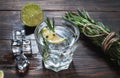 Alcoholic drink - gin tonic cocktail - with lime, rosemary and ice on rustic wooden table Royalty Free Stock Photo