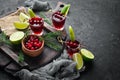 Alcoholic liqueur from a cranberry in a glass. Cranberry, lime, rosemary. On a rustic background.