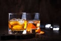 Alcoholic old fashioned cocktail with orange slice, cherry and orange peel garnish Royalty Free Stock Photo