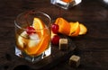Alcoholic old fashioned cocktail with orange slice, cherry and orange peel garnish Royalty Free Stock Photo