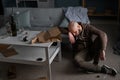 alcoholism, alcohol addiction concept. Male alcoholic with glass of whiskey sleeping near table on floor Royalty Free Stock Photo