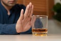 Alcoholism, depressed asian young man refuse, push out alcoholic beverage glass, drink whiskey, sitting alone at night. Treatment Royalty Free Stock Photo