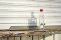 Alcoholism problem concept picture of empty vodka bottle on dirty windowsill white kiosk background plastic view slum ghetto urban