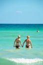 Alcudia, Spain 14.09.2011 - A couple holding hands in the sea. Two womans couple enjoying summer sun on vacation. Mallorca island