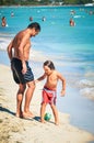 Alcudia, Spain 14.09.2011 - Father with son playing a ball near sea at beach and having fun. People sunbathing at Playa de Muro.