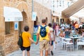 ALCUDIA, SPAIN - July 8, 2019: Restaurant tables on street with tourists in seaside Alcudia old town, Mallorca island