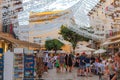 ALCUDIA, SPAIN - July 8, 2019: Restaurant tables on street with tourists in seaside Alcudia old town, Mallorca island