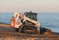 Bobcat T650 Track Loader moving shingle on Aldeburgh beach. UK Royalty Free Stock Photo