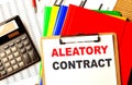 ALEATORY CONTRACT text on clipboard with calculator and color folder Royalty Free Stock Photo
