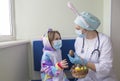 Easter in the hospital: the doctor nurse gives the girl a chocolate egg