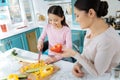 Alert girl smiling and chopping vegetables