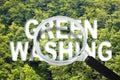 Alert to Greenwashing - concept with text against a forest and trees and magnifying glass Royalty Free Stock Photo