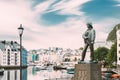 Alesund, Norway. Statue Of Young Sailor-fisher Boy On Brosundet Canal. Old Wooden Houses In Summer Day Royalty Free Stock Photo