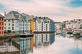 Alesund, Norway. Young Woman Tourist Traveler Photographer Taking Pictures Photos Of Old Wooden Houses In Cloudy Summer