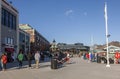 A sunny day in the waterfront district of historic Alexandria with people walking by the Potomac river. Royalty Free Stock Photo