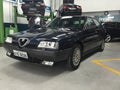 Alfa Romeo 164: Front view, dark blue color, in a workshop.