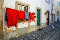 Alfama Lisboa narrow street colored houses ad clothes, Lisbon Portugal