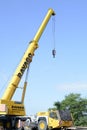 Detail of a yellow construction telescopic mobile crane on blue sky