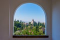 The alhambra through the arched window from the generalife gardens in granada, spain Royalty Free Stock Photo