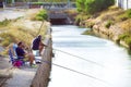 Alicante, Spain, August 28, 2019: Two men fishing by the river s