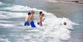 Alicante, Spain, August 20, 2019: Young children play happily with the waves at the beach Royalty Free Stock Photo