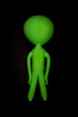 Alien. Blank inflatable little green man. Stereotypical body shape isolated against black background. Royalty Free Stock Photo