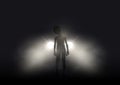Alien in car headlights on foggy night